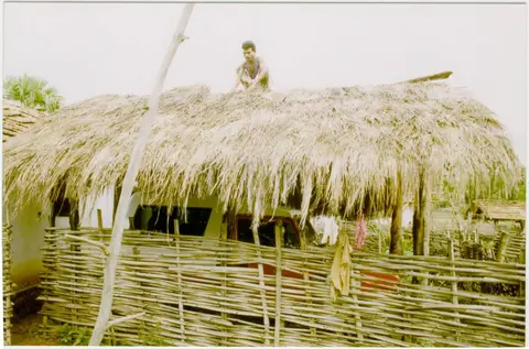 कोळ्कापोग़ोन ईंदिङ वेसना  Laying "inding" grass on the tiled roof of a shed